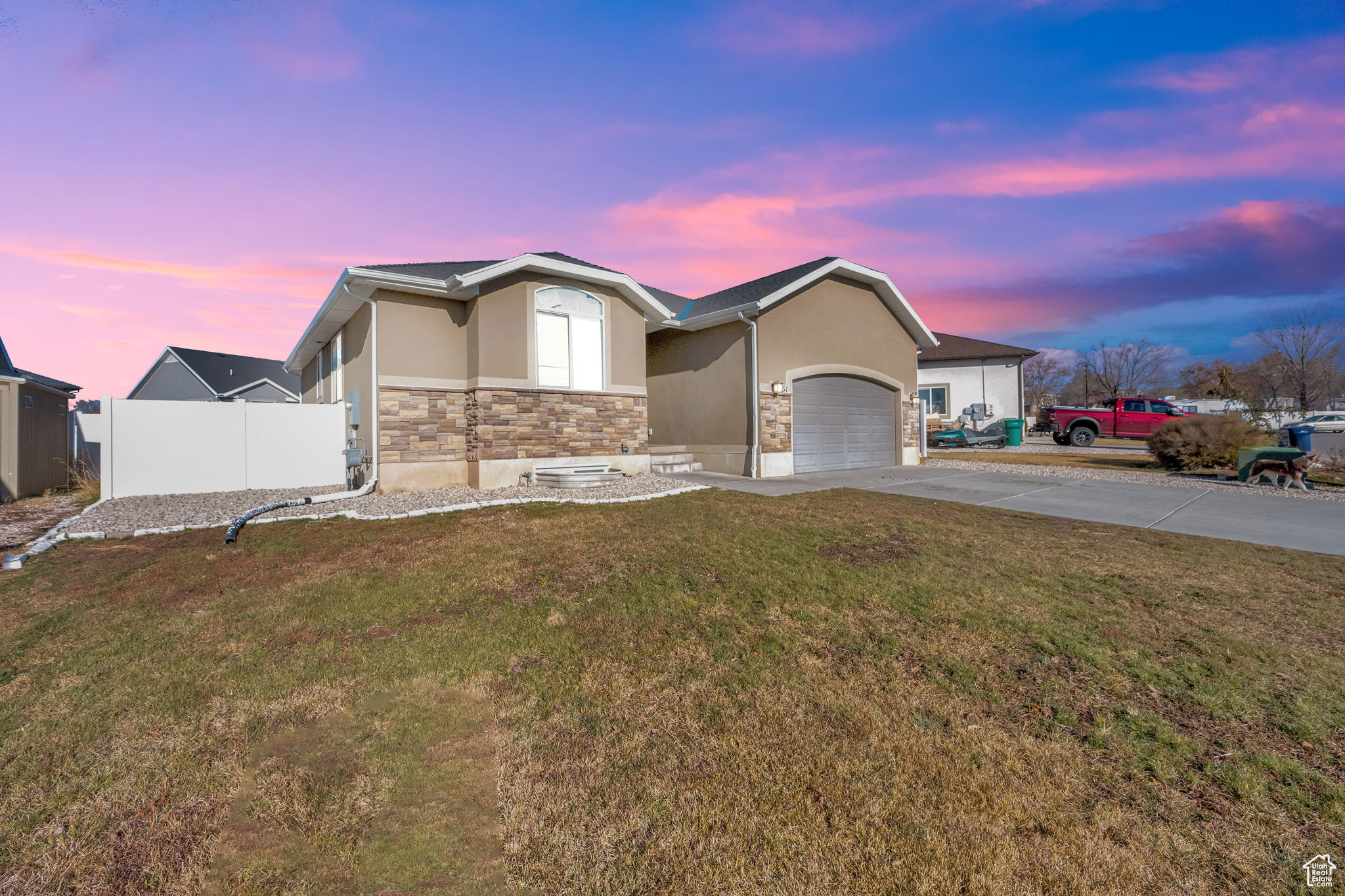 View of front of property featuring a lawn and a garage