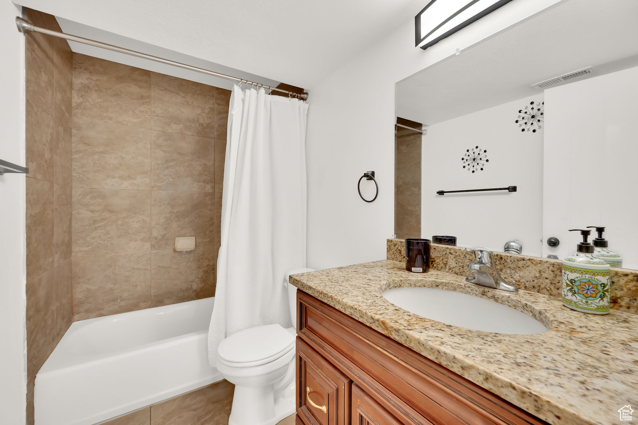 Full bathroom featuring tile patterned floors, shower / bath combo, toilet, and vanity