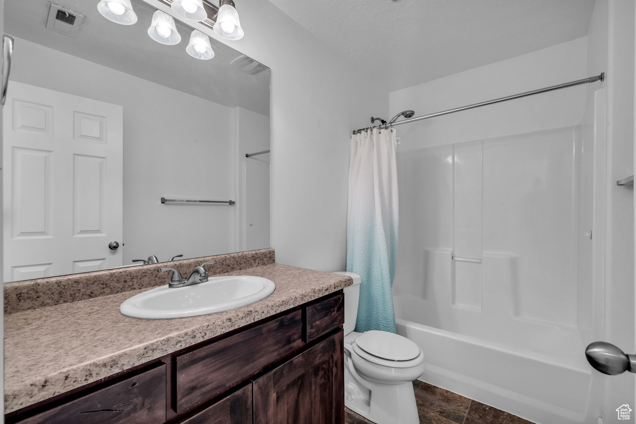 Full bathroom featuring vanity, toilet, and shower / tub combo