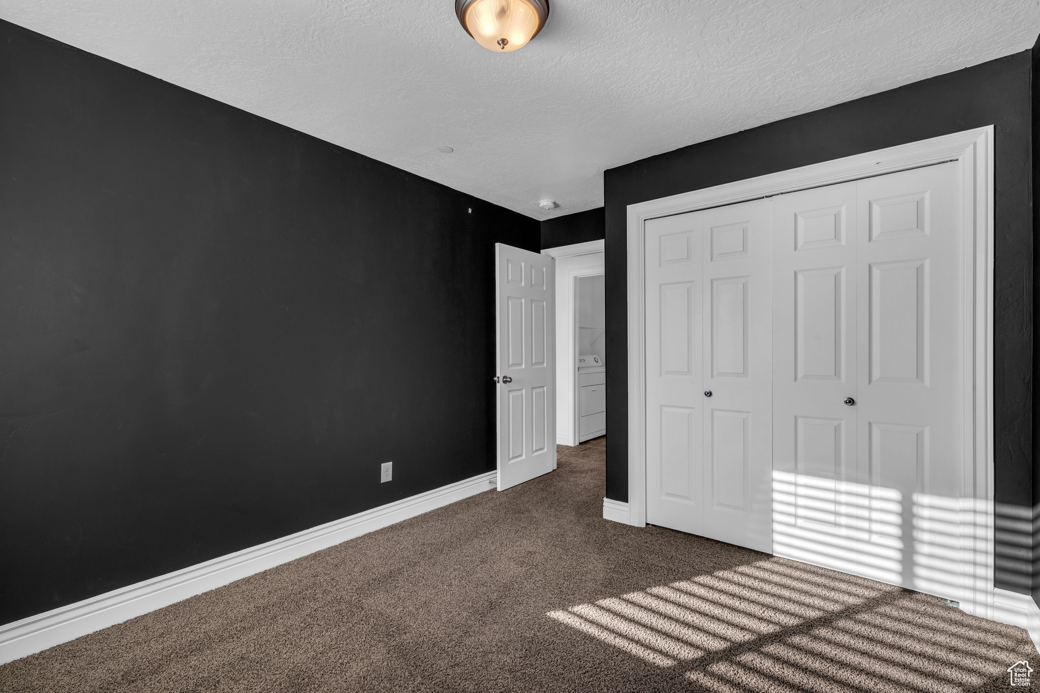 Bedroom 1 with carpet floors and a textured ceiling