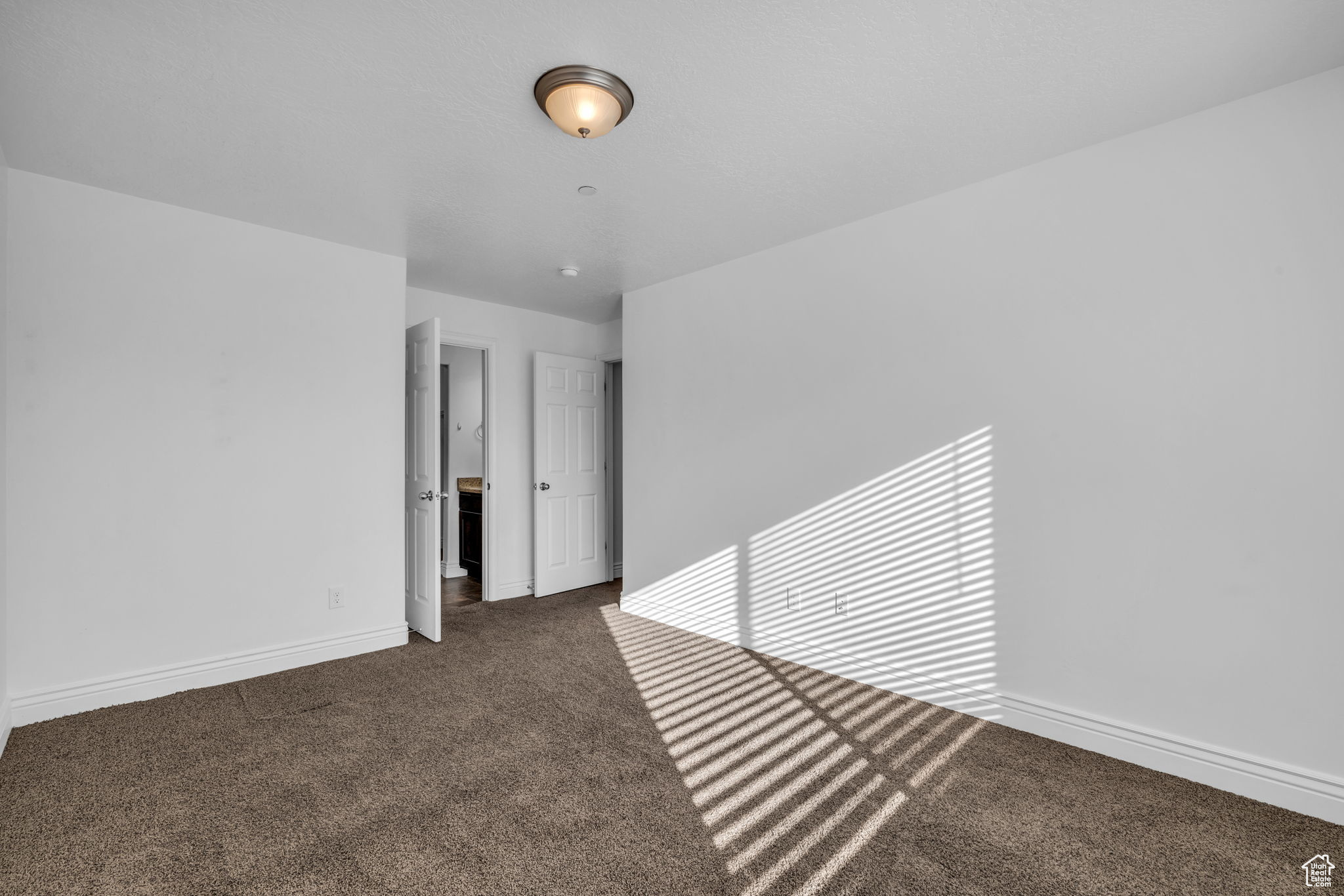 Owners Suite Bedroom 3 with carpet floors and a textured ceiling