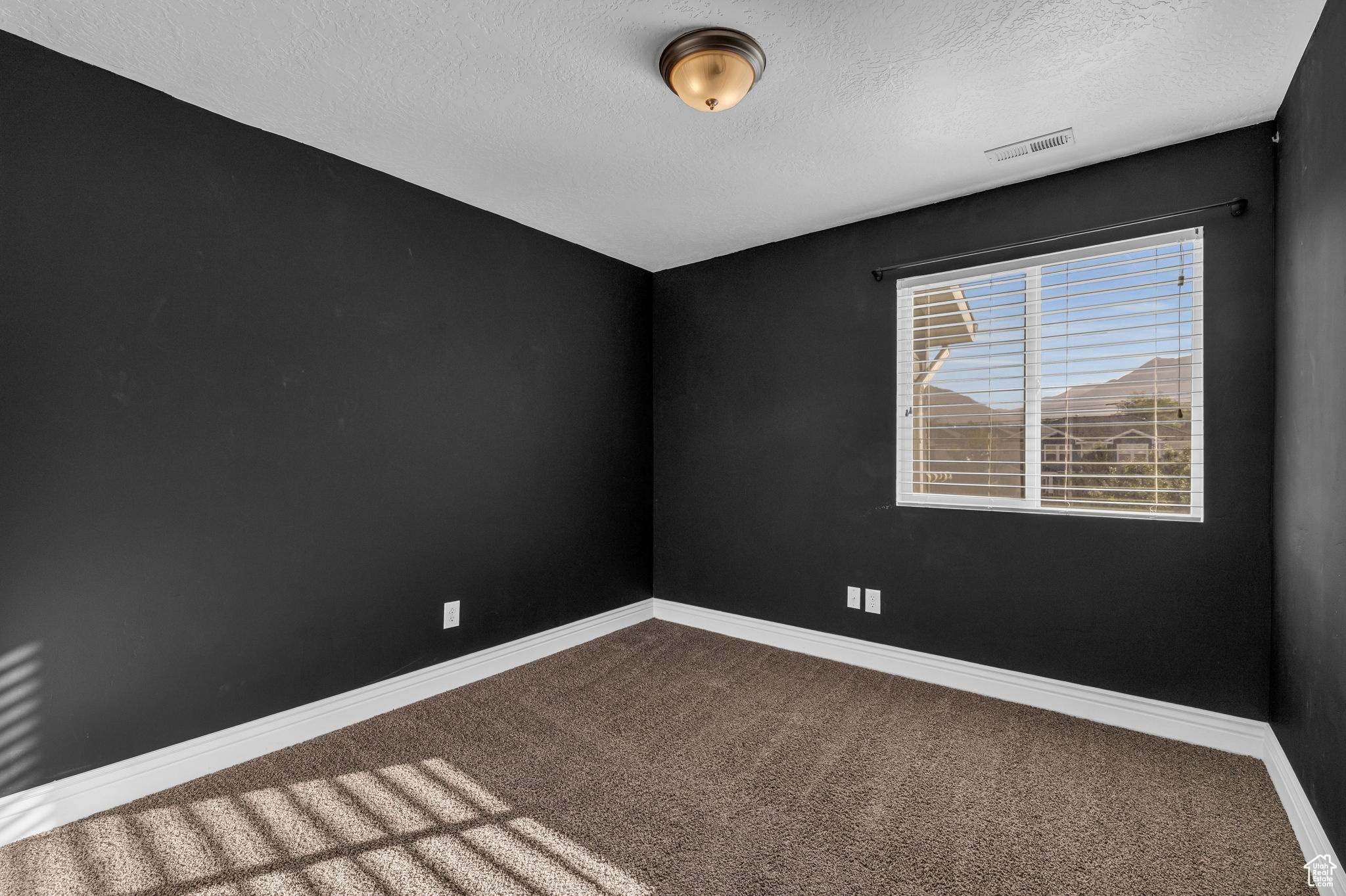 Bedroom 1 with carpet floors and a textured ceiling