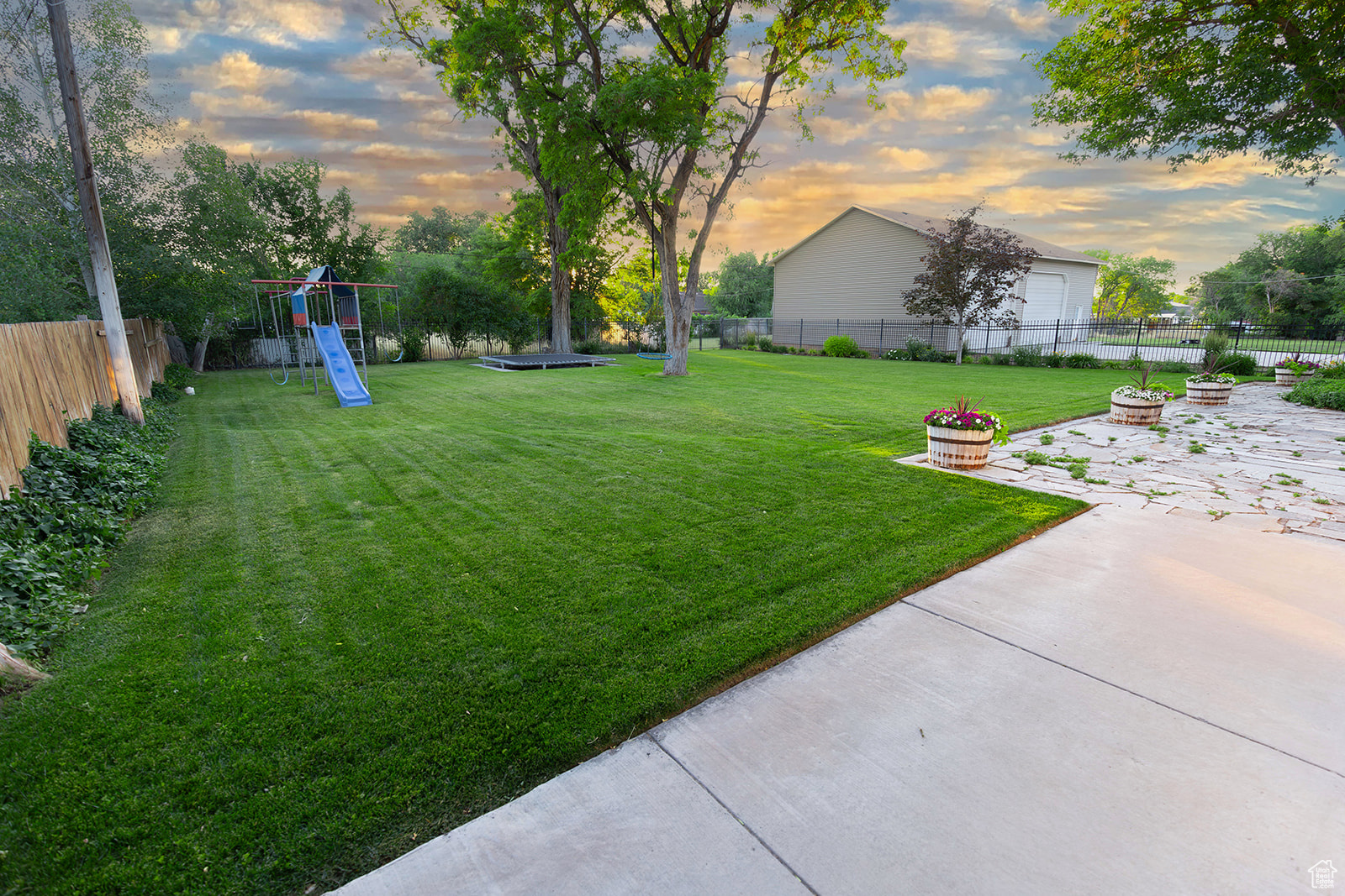 Yard at dusk with a patio and a playground