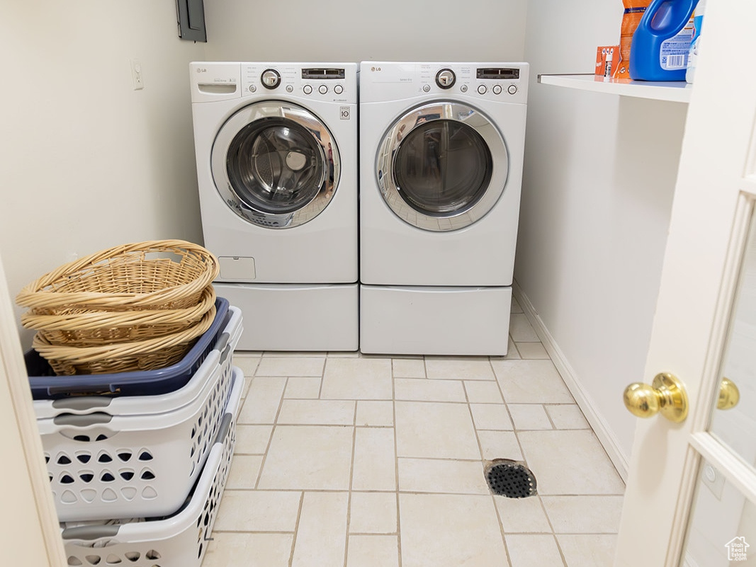 Laundry area with tile patterned flooring and independent washer and dryer