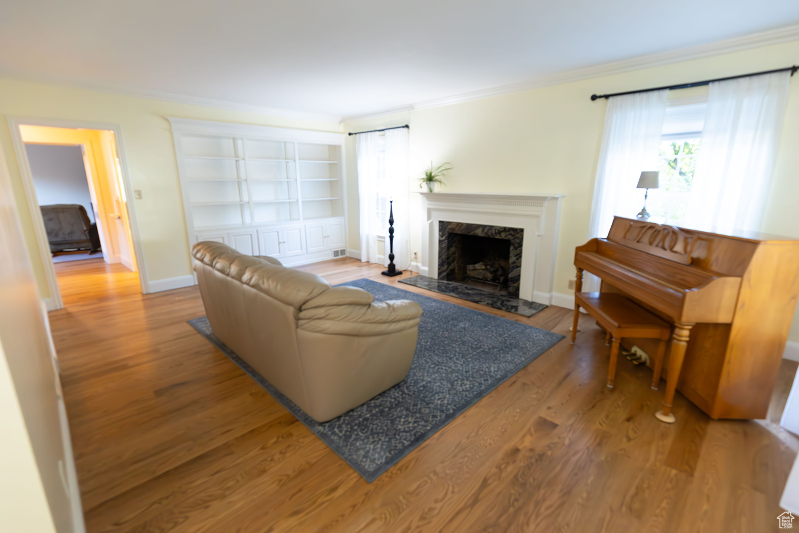 Living room with a fireplace, hardwood / wood-style flooring, and crown molding