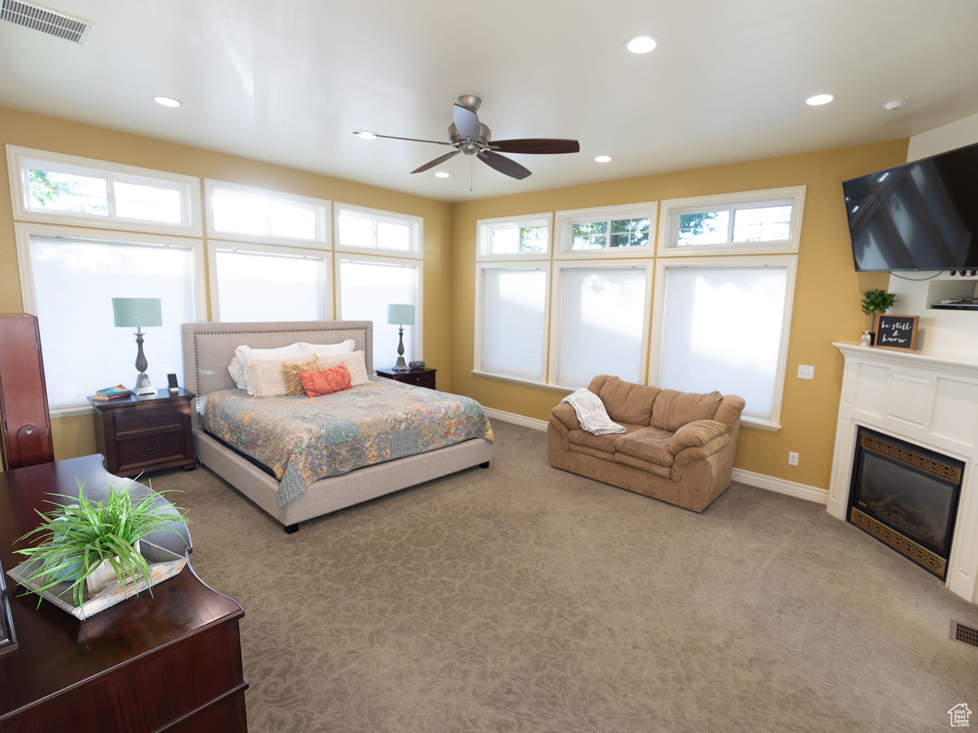 Bedroom with ceiling fan and light carpet