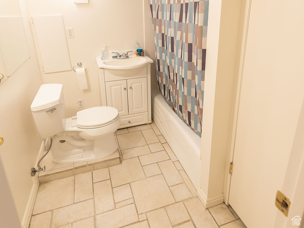 Full bathroom featuring vanity, shower / bath combination with curtain, and toilet