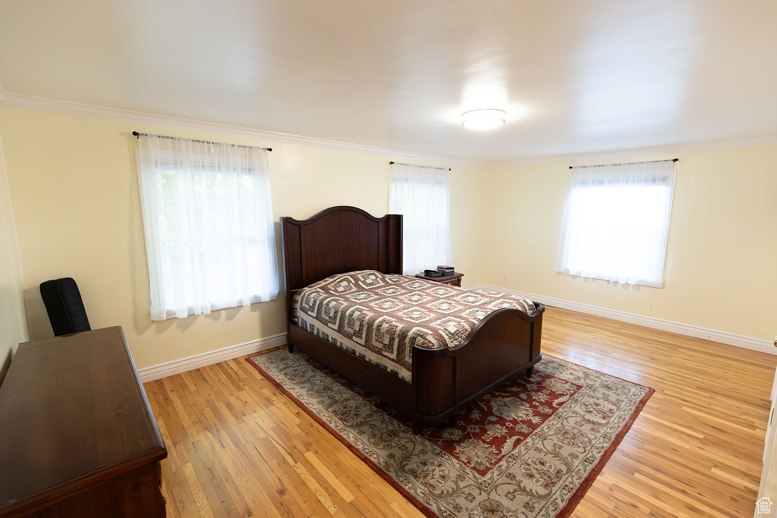 Bedroom featuring hardwood / wood-style flooring and crown molding