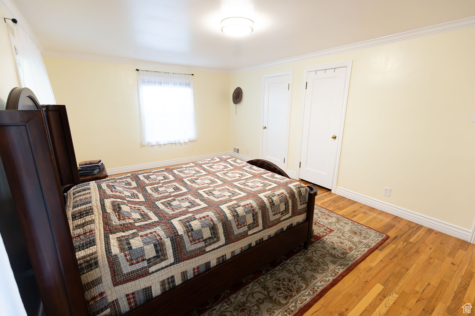 Bedroom with light wood-type flooring and ornamental molding