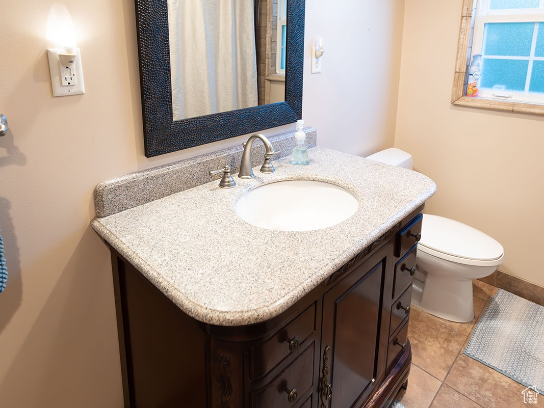 Bathroom with tile patterned floors, vanity, and toilet