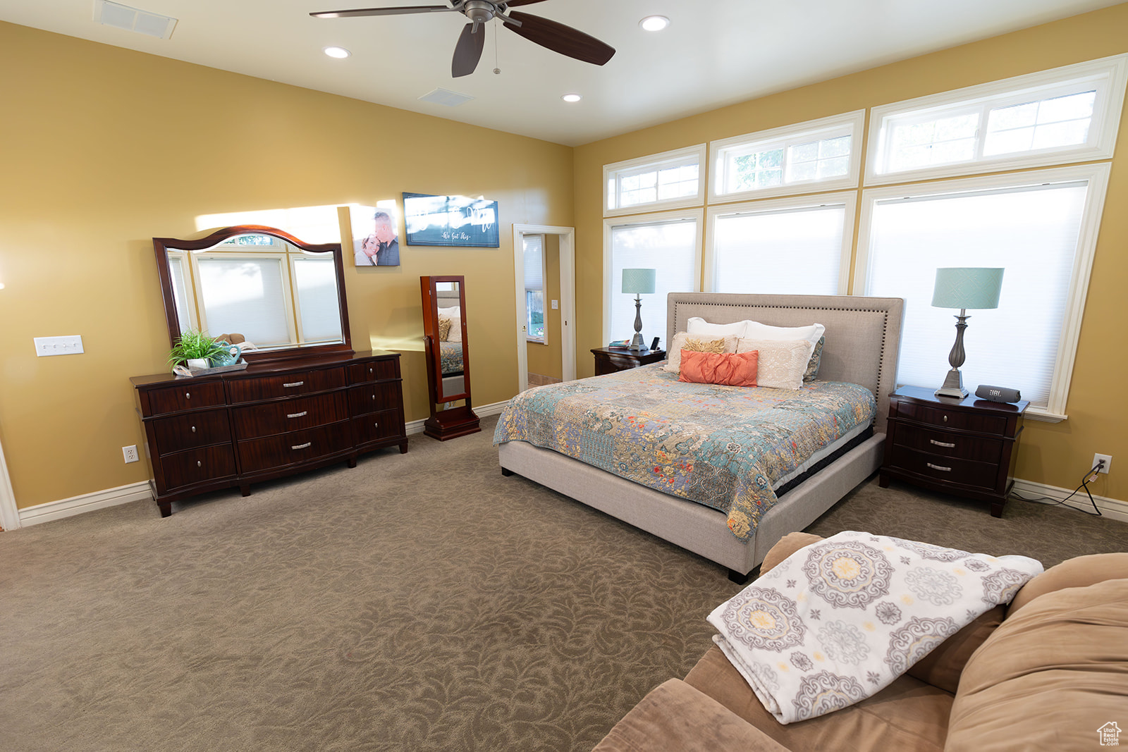 Bedroom with ceiling fan and dark colored carpet