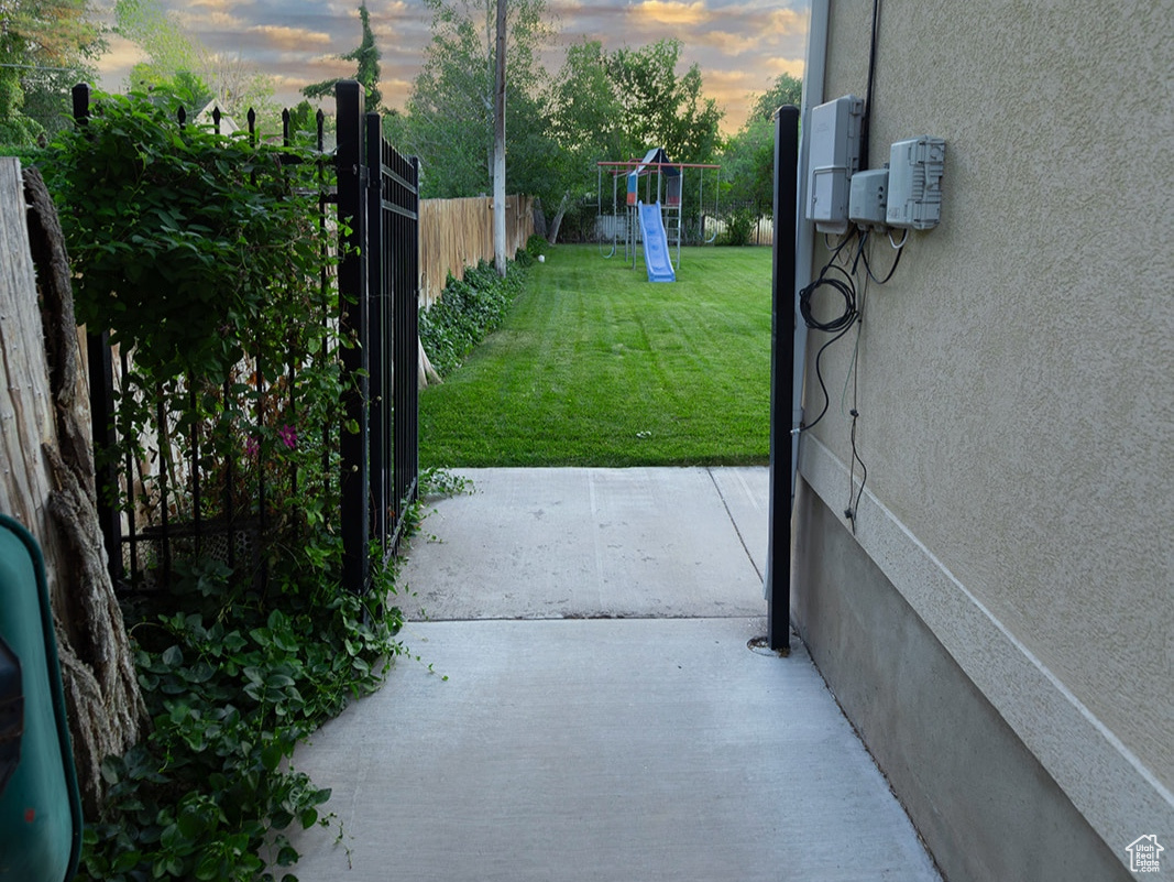 Gate at dusk with a lawn and a patio