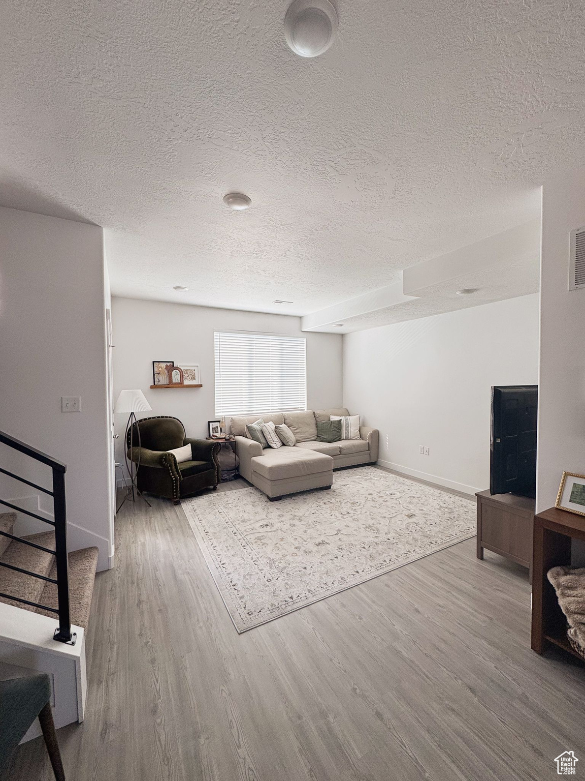 Living room featuring hardwood / wood-style floors and a textured ceiling