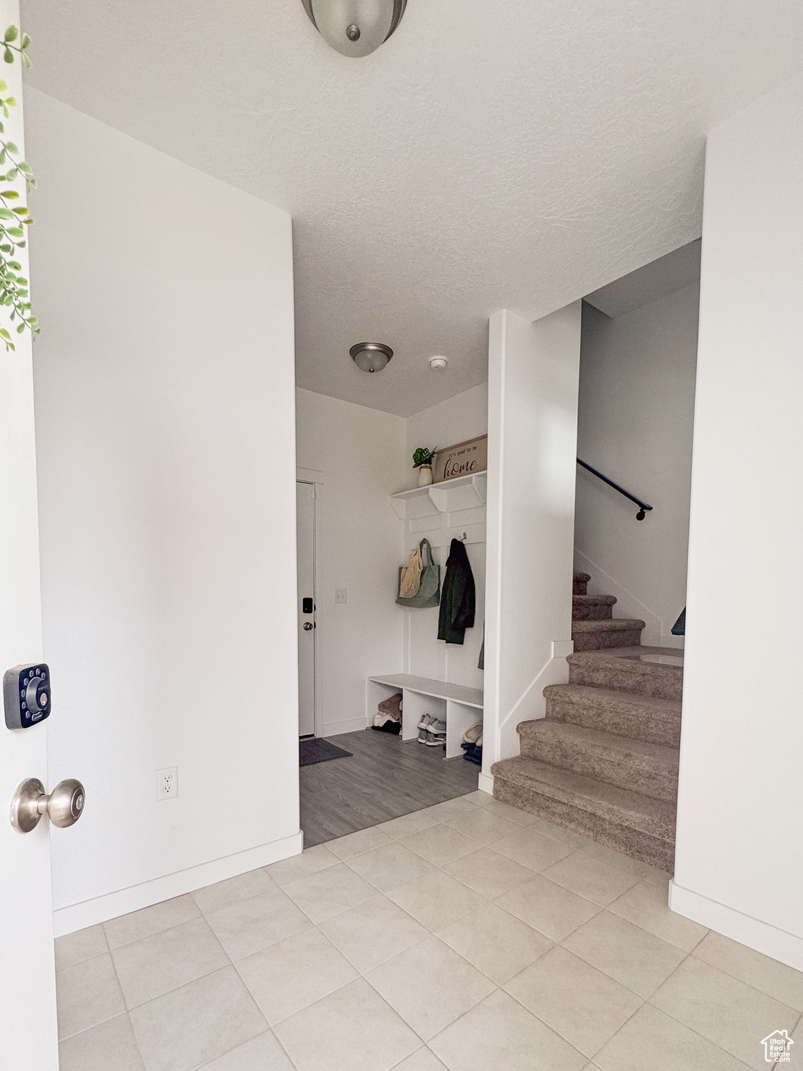 Foyer entrance featuring light tile patterned floors and a textured ceiling