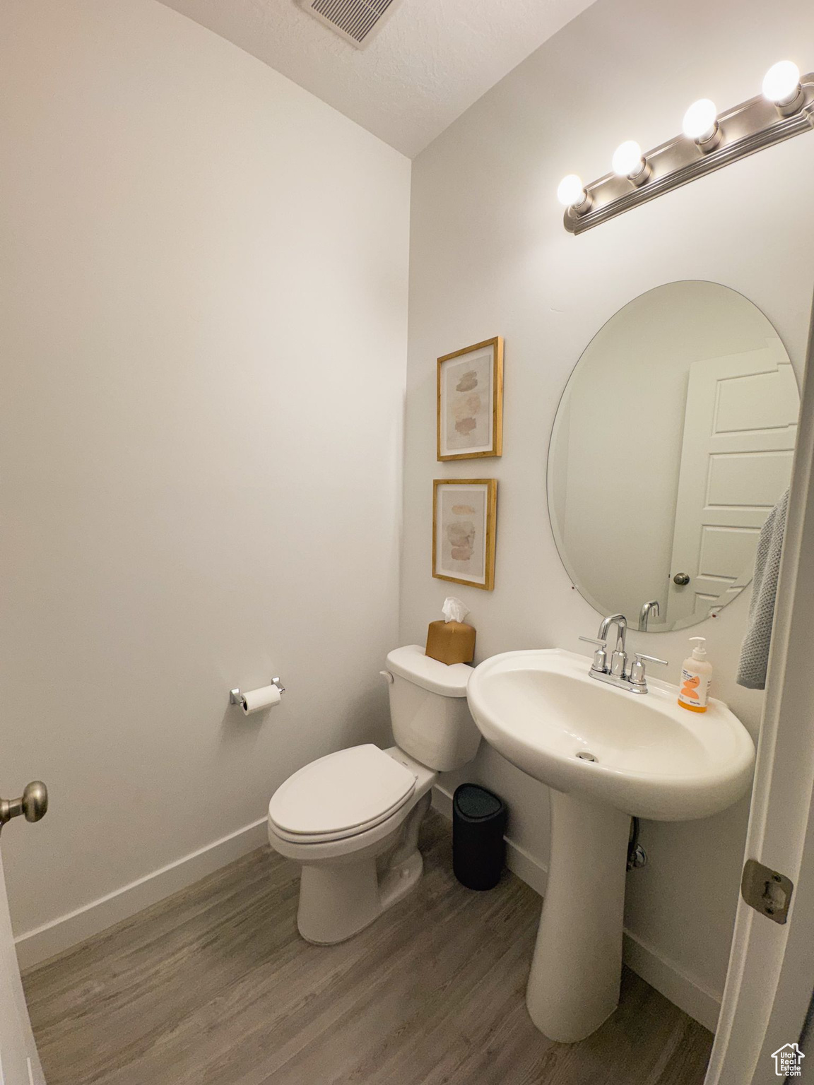 Bathroom with toilet, a textured ceiling, and hardwood / wood-style flooring