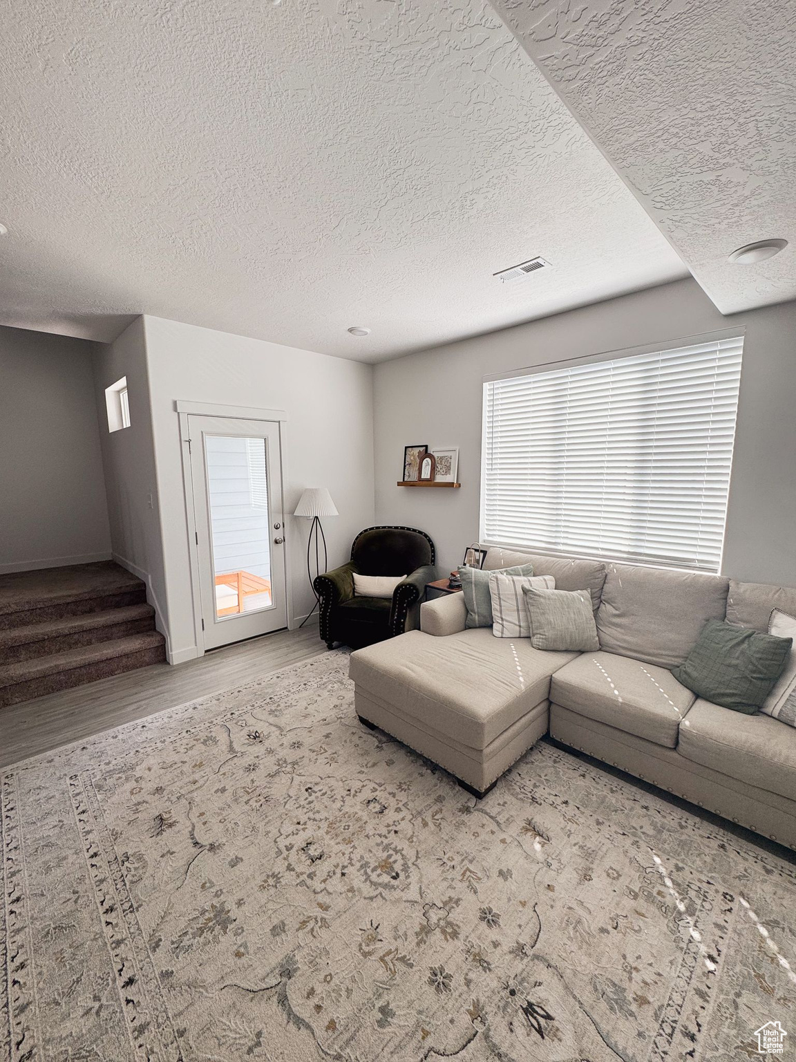 Living room with wood-type flooring and a textured ceiling