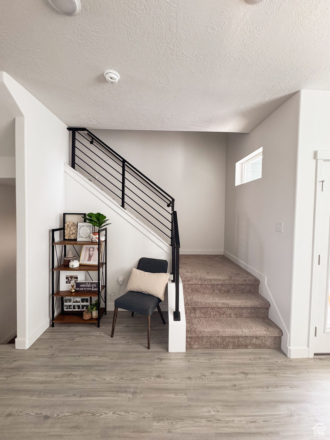 Staircase featuring wood-type flooring and a textured ceiling