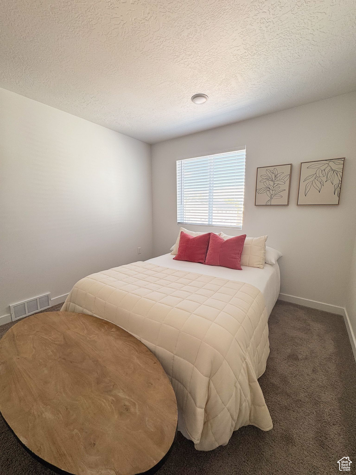 Bedroom featuring dark carpet and a textured ceiling