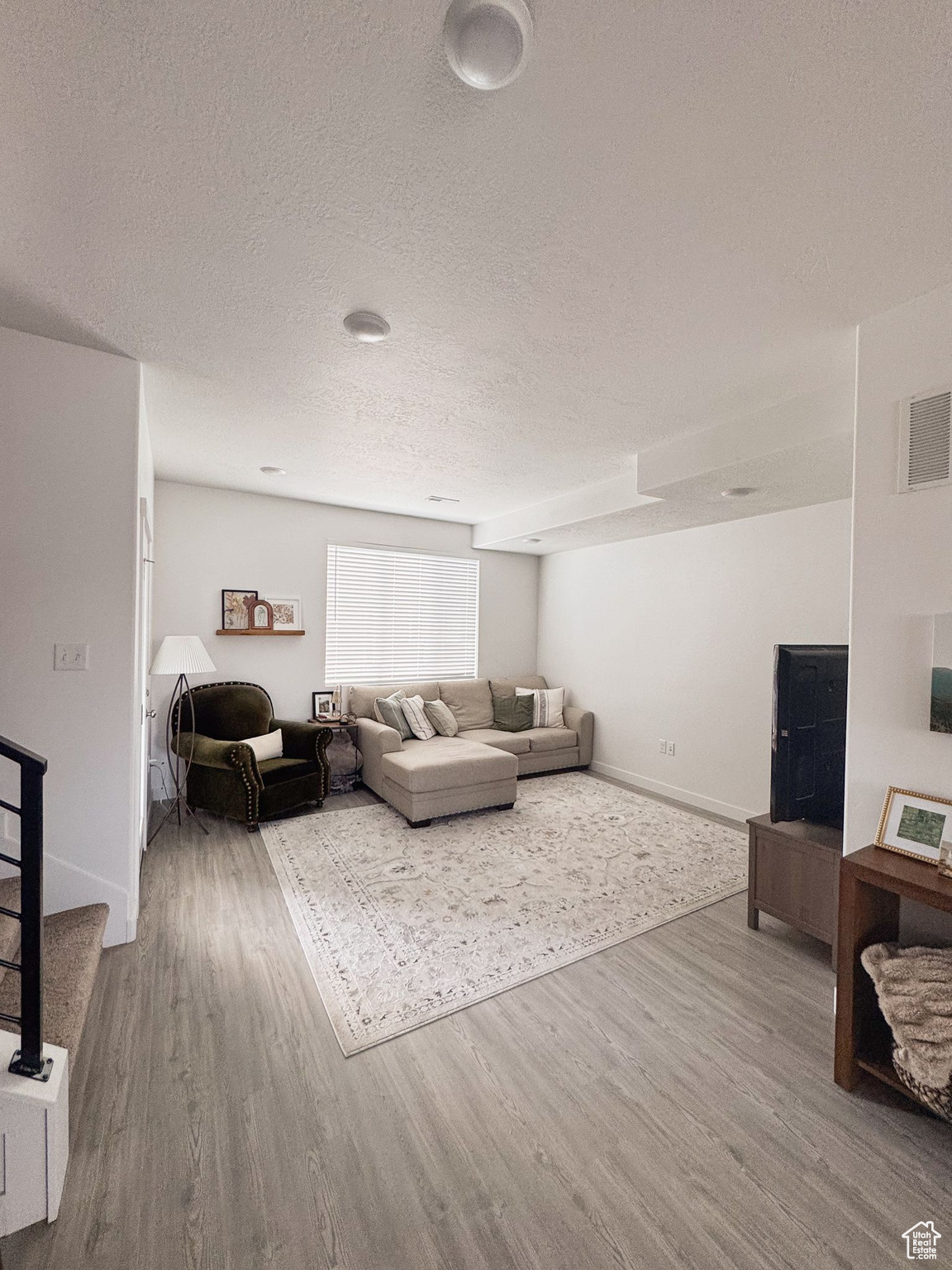 Living room with hardwood / wood-style floors and a textured ceiling