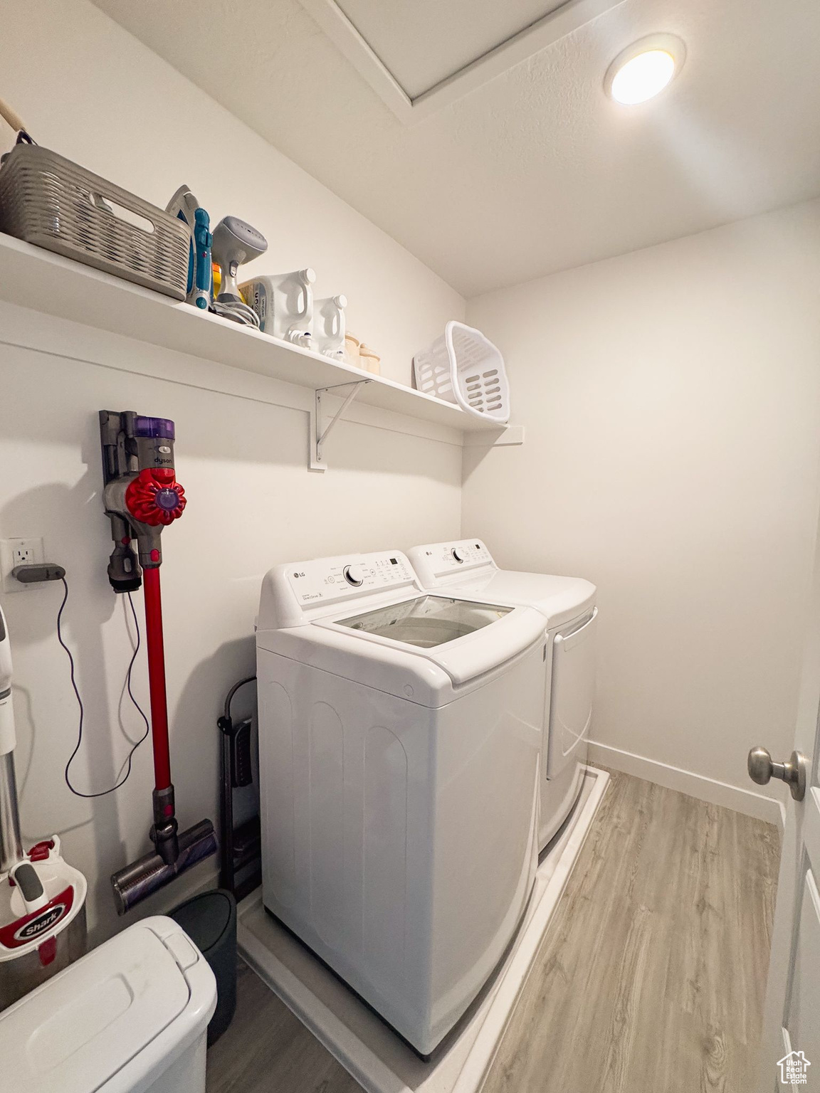 Clothes washing area with hardwood / wood-style floors and washing machine and dryer