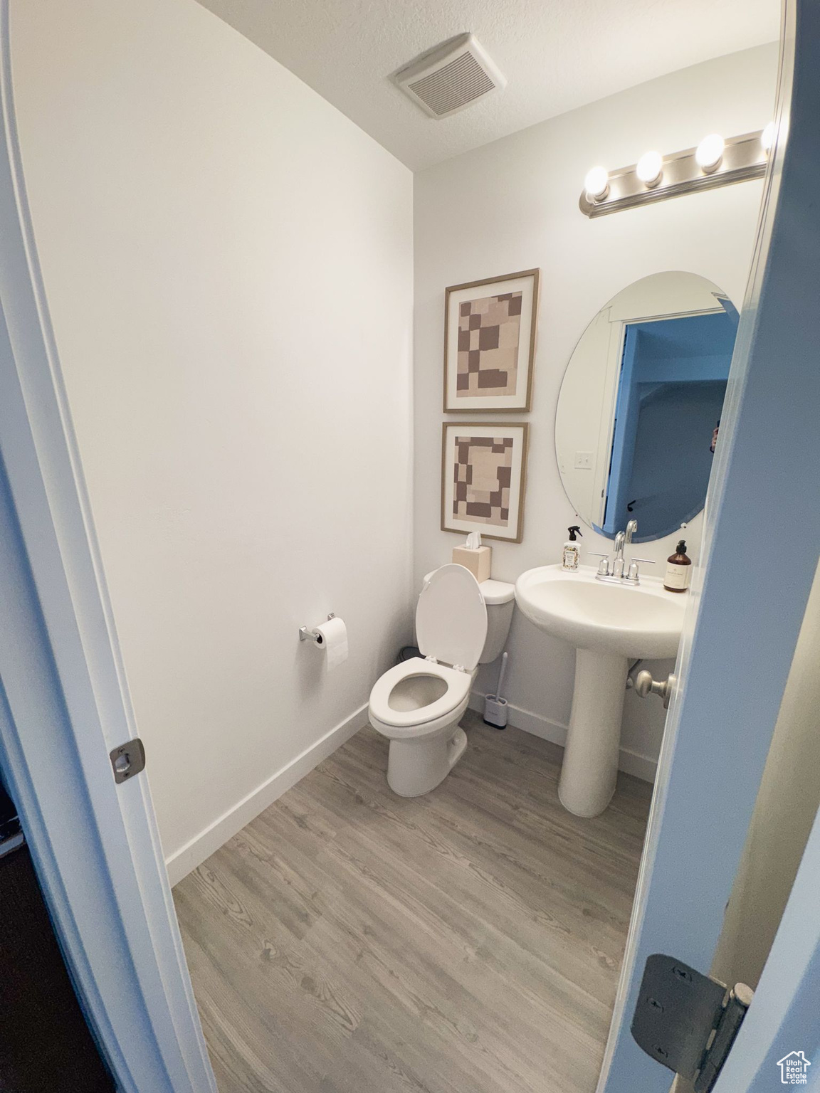 Bathroom featuring hardwood / wood-style flooring, toilet, and a textured ceiling