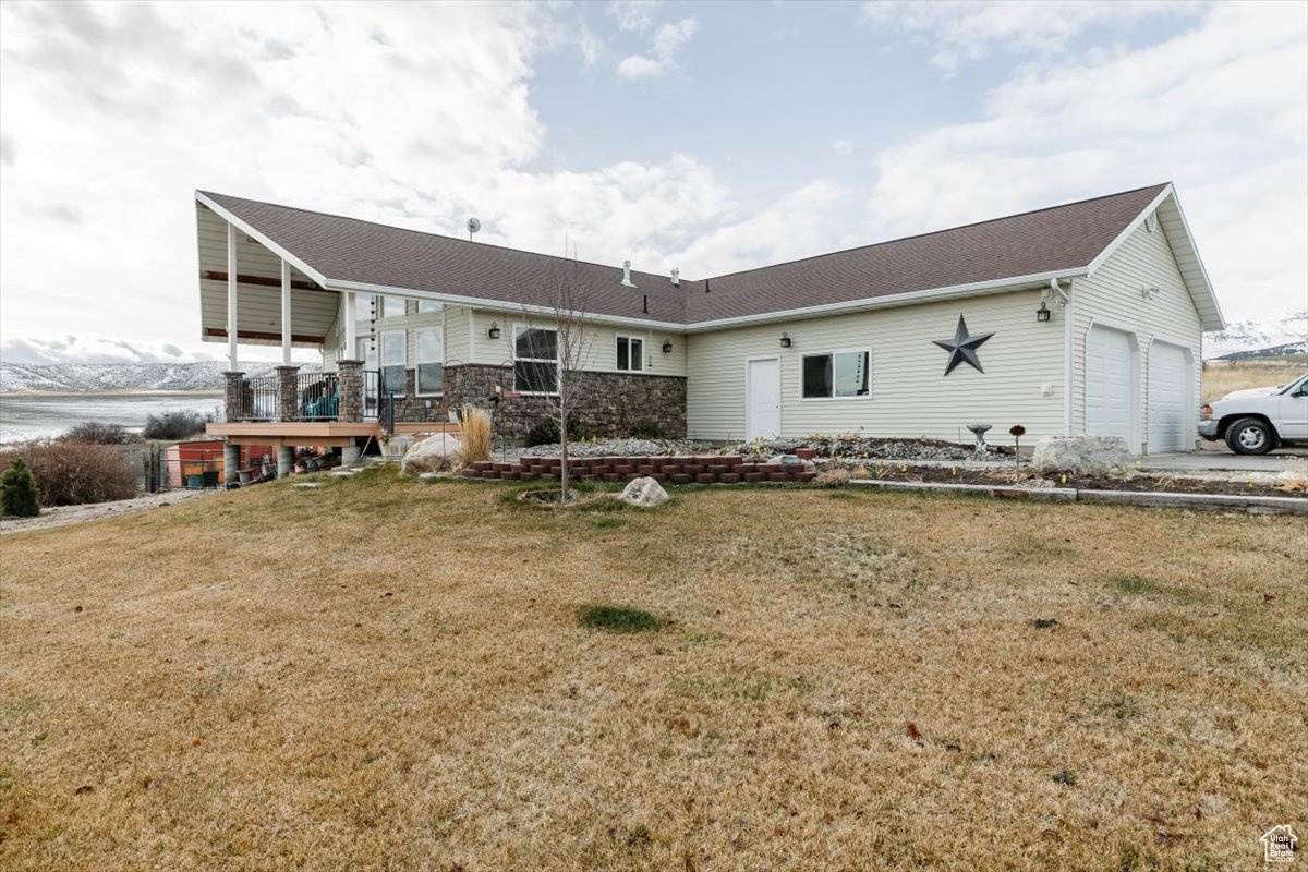 Rear view of property with a lawn and a garage