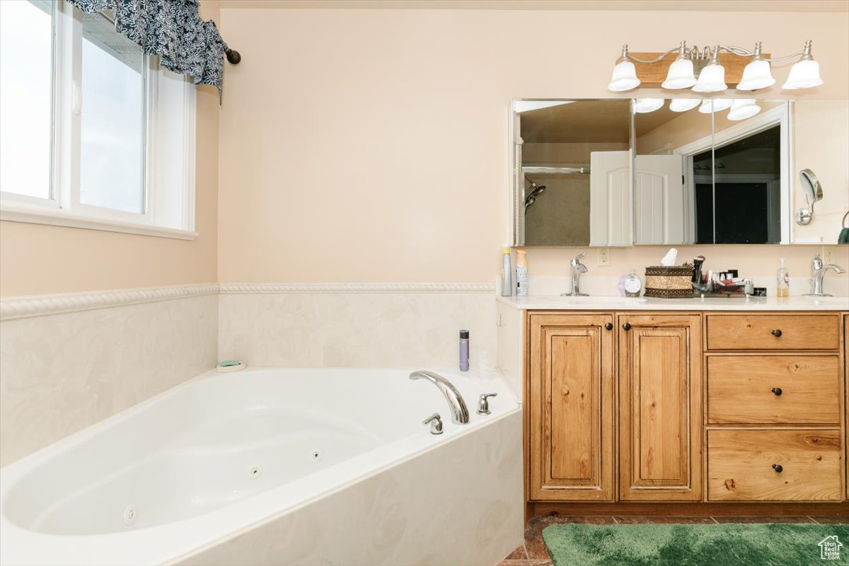 Bathroom featuring tile patterned floors, plus walk in shower, and vanity