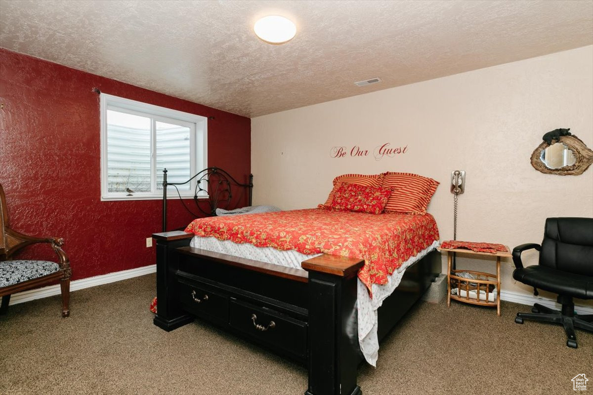 Bedroom featuring carpet floors and a textured ceiling