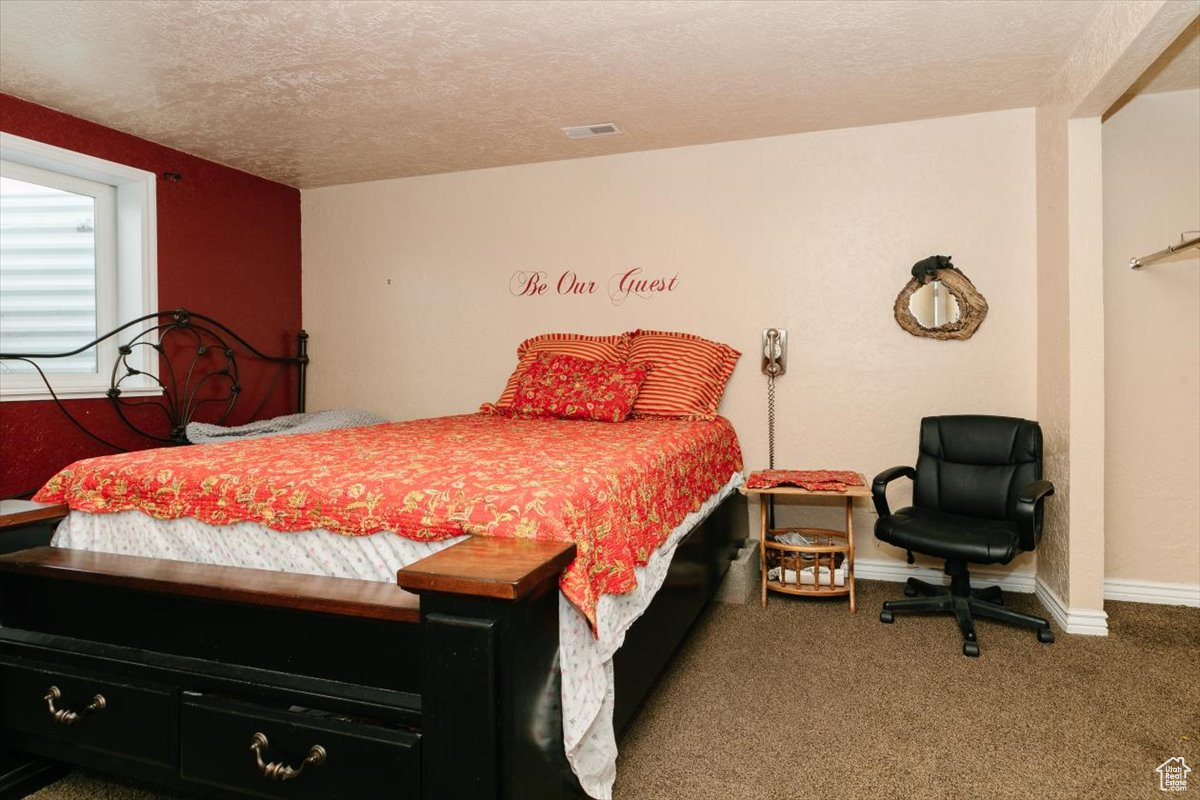 Carpeted bedroom with a textured ceiling