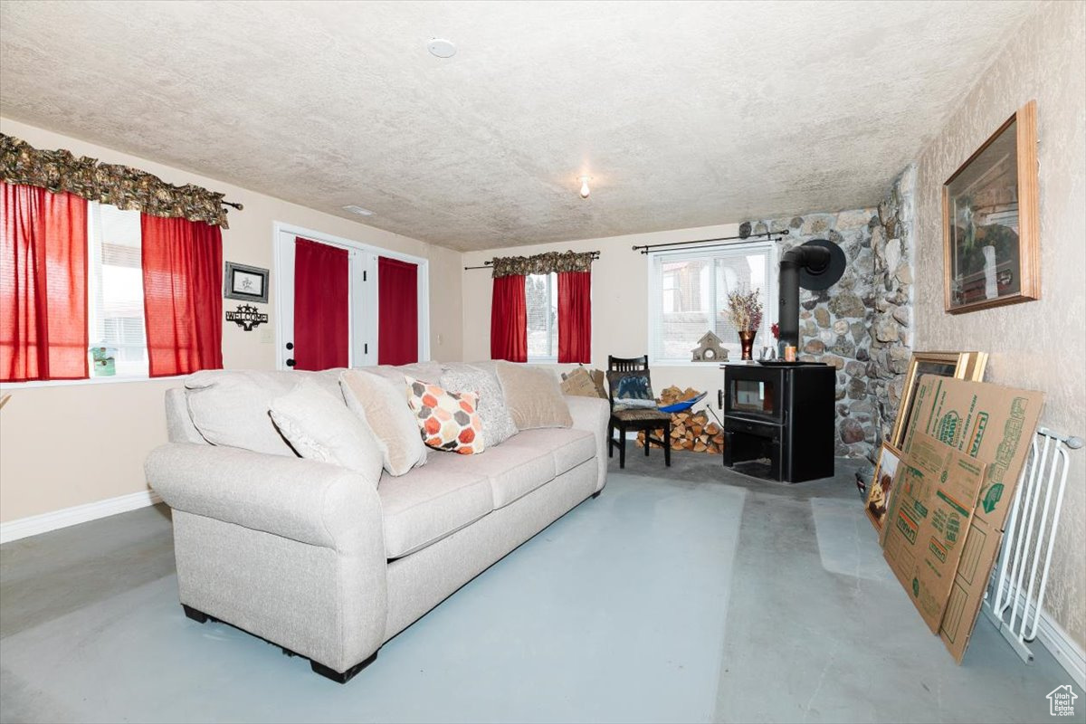 Living room with a wood stove and concrete flooring