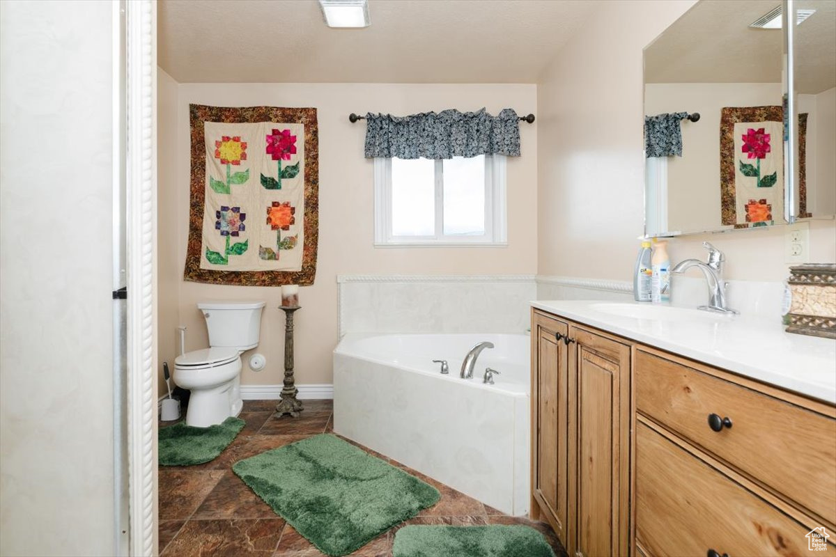 Bathroom featuring vanity, toilet, and a tub