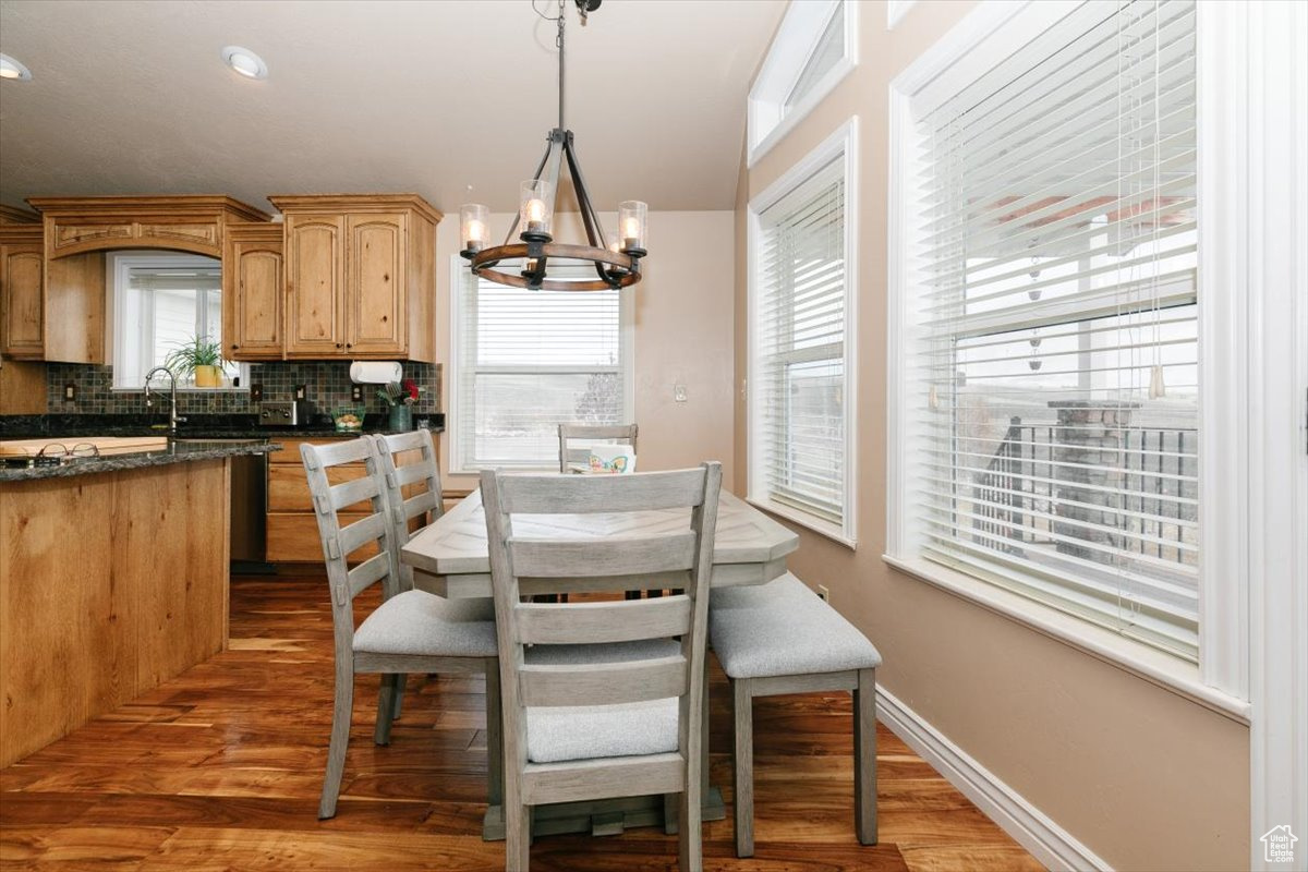 Dining room featuring a notable chandelier, light hardwood / wood-style floors, and a healthy amount of sunlight