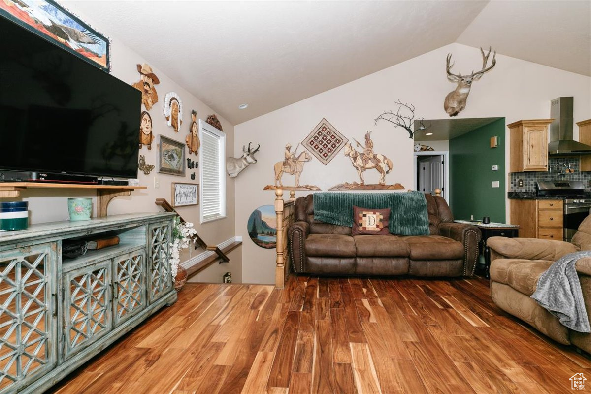 Living room featuring vaulted ceiling and hardwood / wood-style flooring