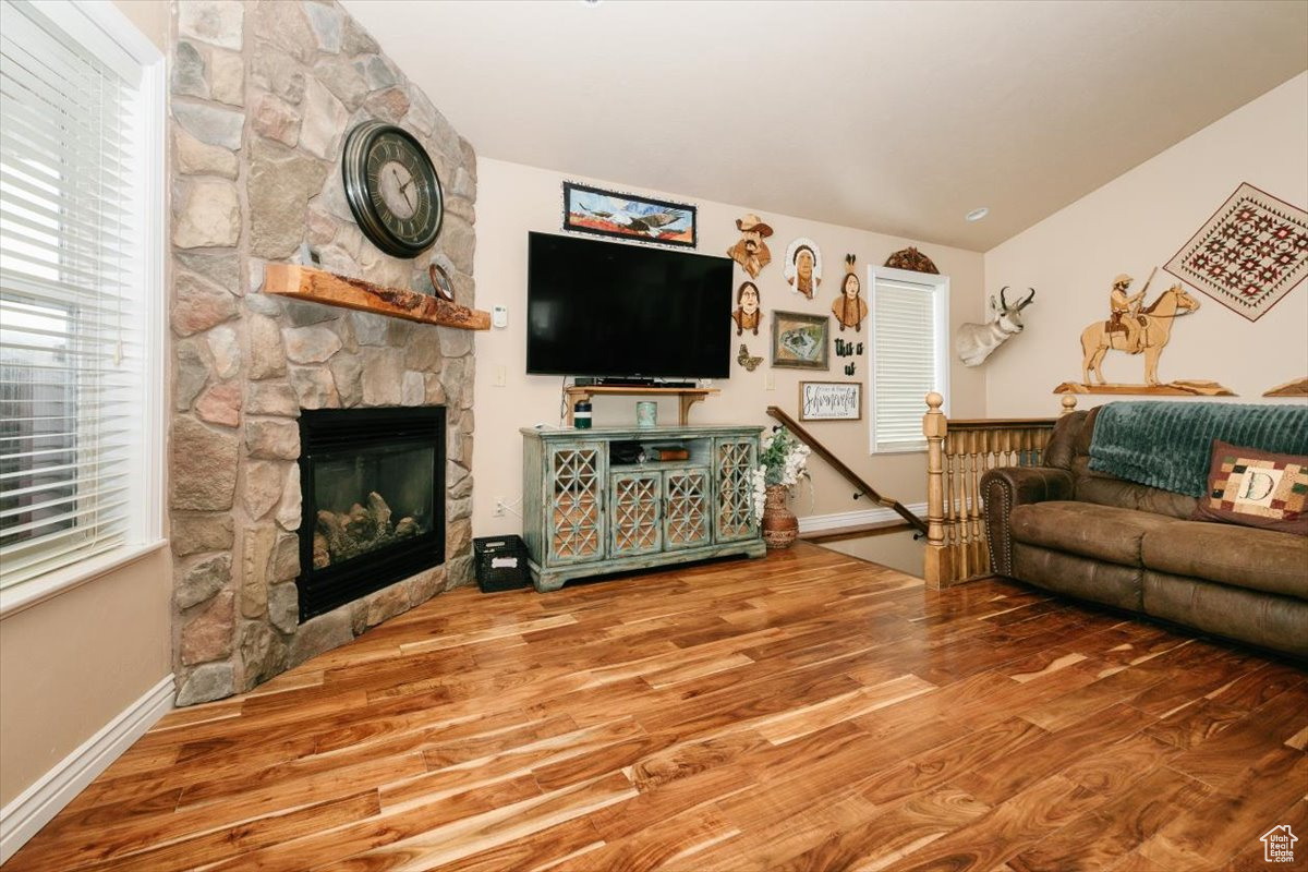 Living room with a fireplace, hardwood / wood-style floors, and lofted ceiling