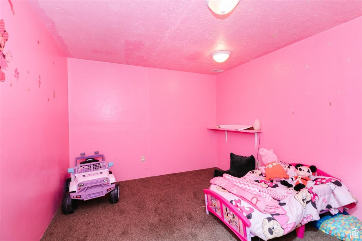 Carpeted bedroom featuring a textured ceiling