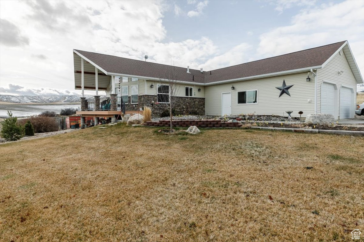 Back of property featuring a yard and a garage