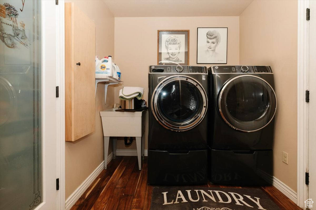 Laundry area featuring dark hardwood / wood-style floors and washer and clothes dryer