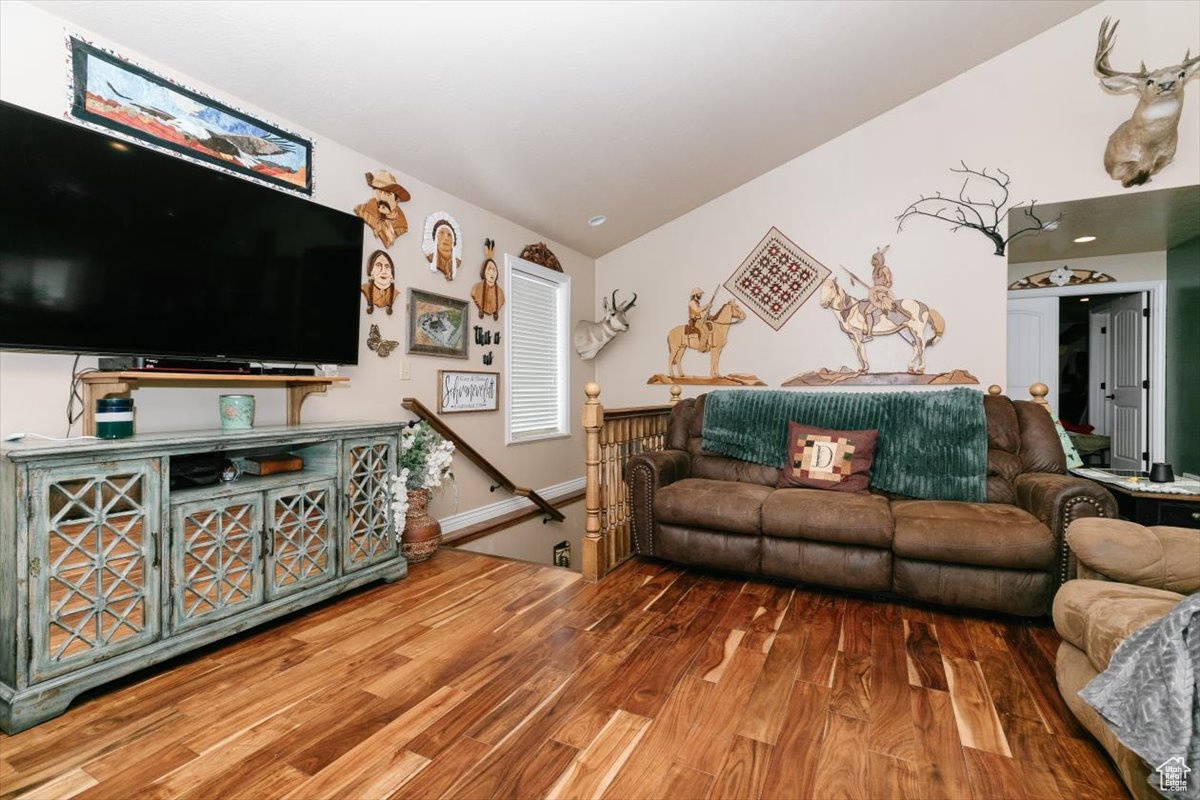 Living room featuring wood-type flooring and vaulted ceiling