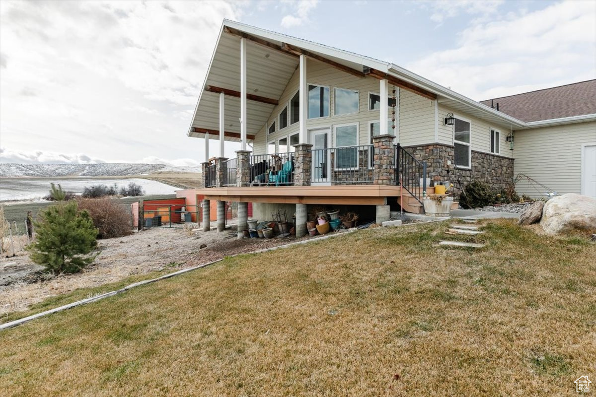 Rear view of house with a yard and a deck with mountain view