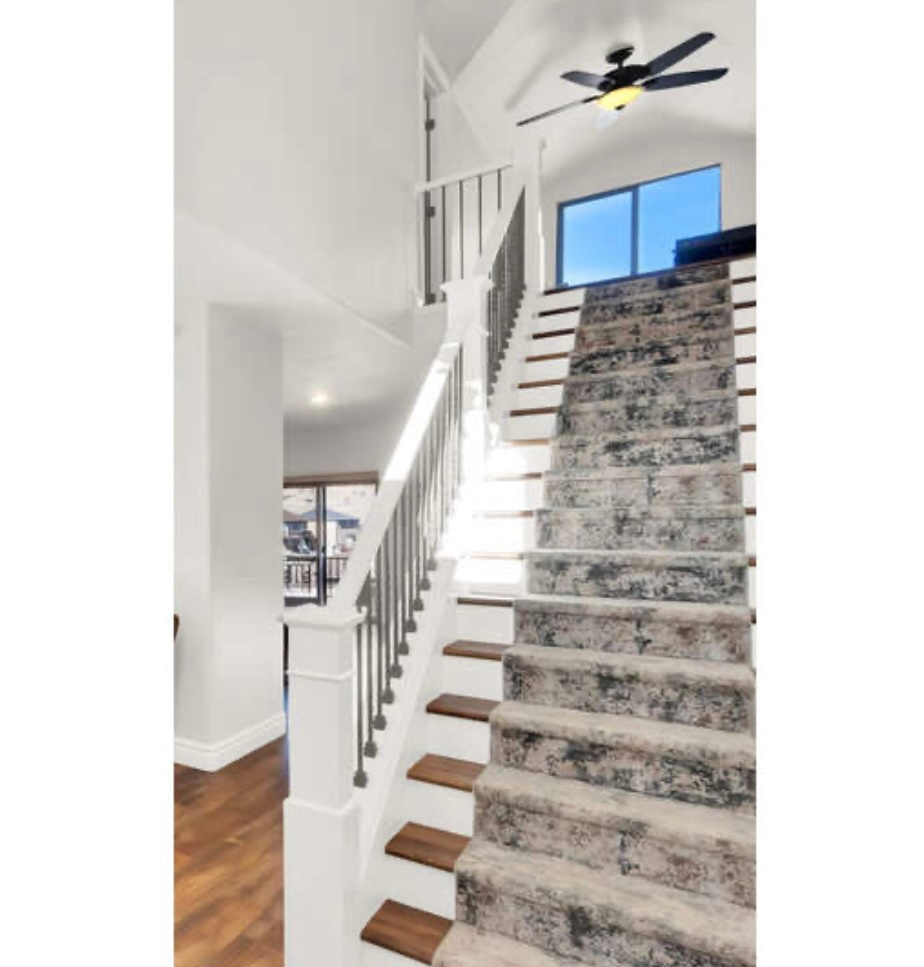 Staircase featuring hardwood / wood-style floors, ceiling fan, and lofted ceiling