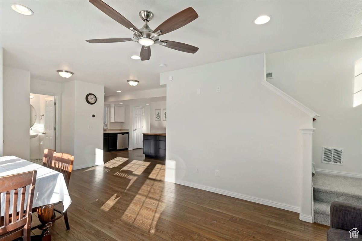 Dining space with ceiling fan and dark wood-type flooring