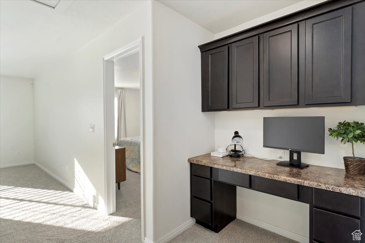 Office area with light carpet and built in desk