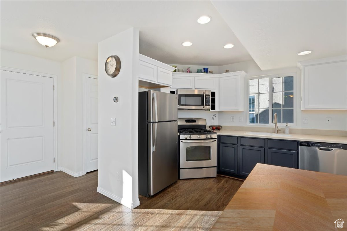 Kitchen with gray cabinetry, white cabinets, sink, dark hardwood / wood-style floors, and stainless steel appliances