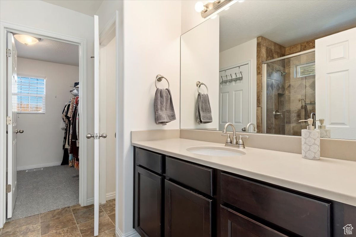 Bathroom with vanity and a shower with shower door