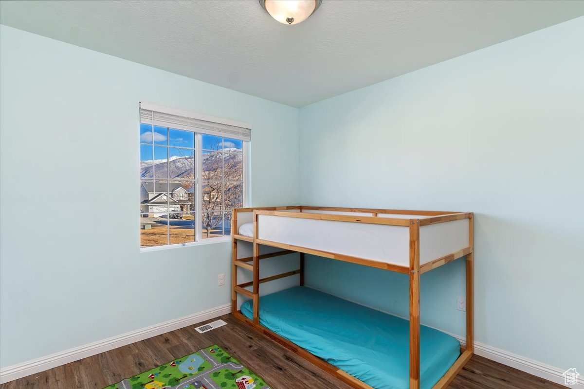 Bedroom featuring a mountain view and dark hardwood / wood-style flooring