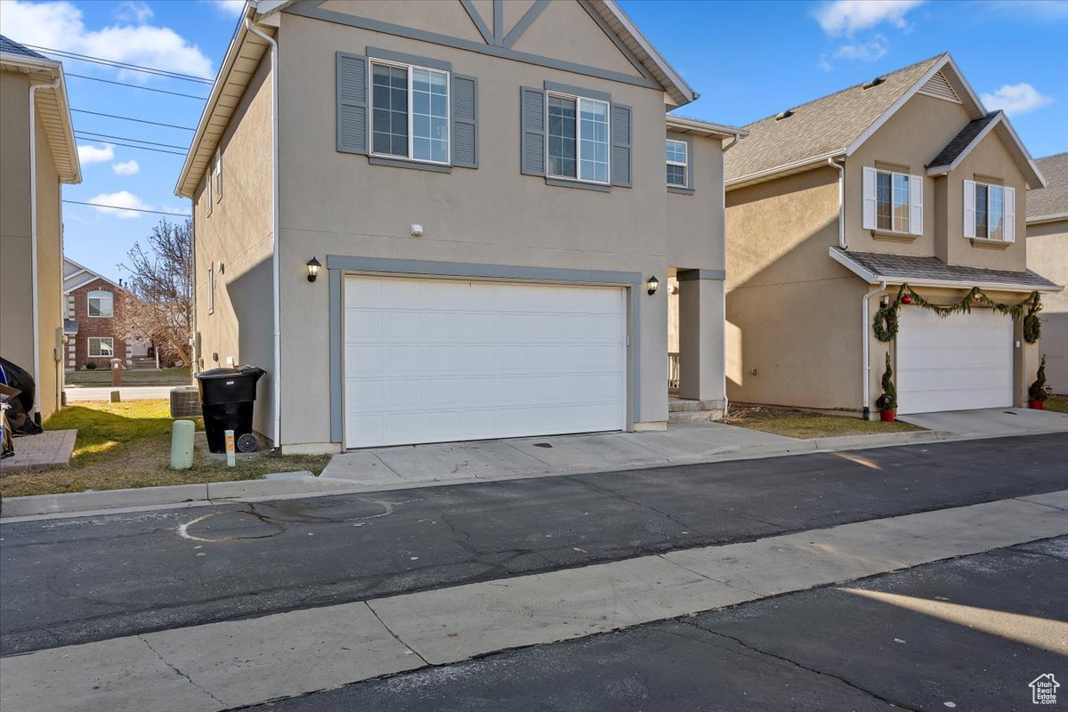 View of front of property featuring central AC and a garage