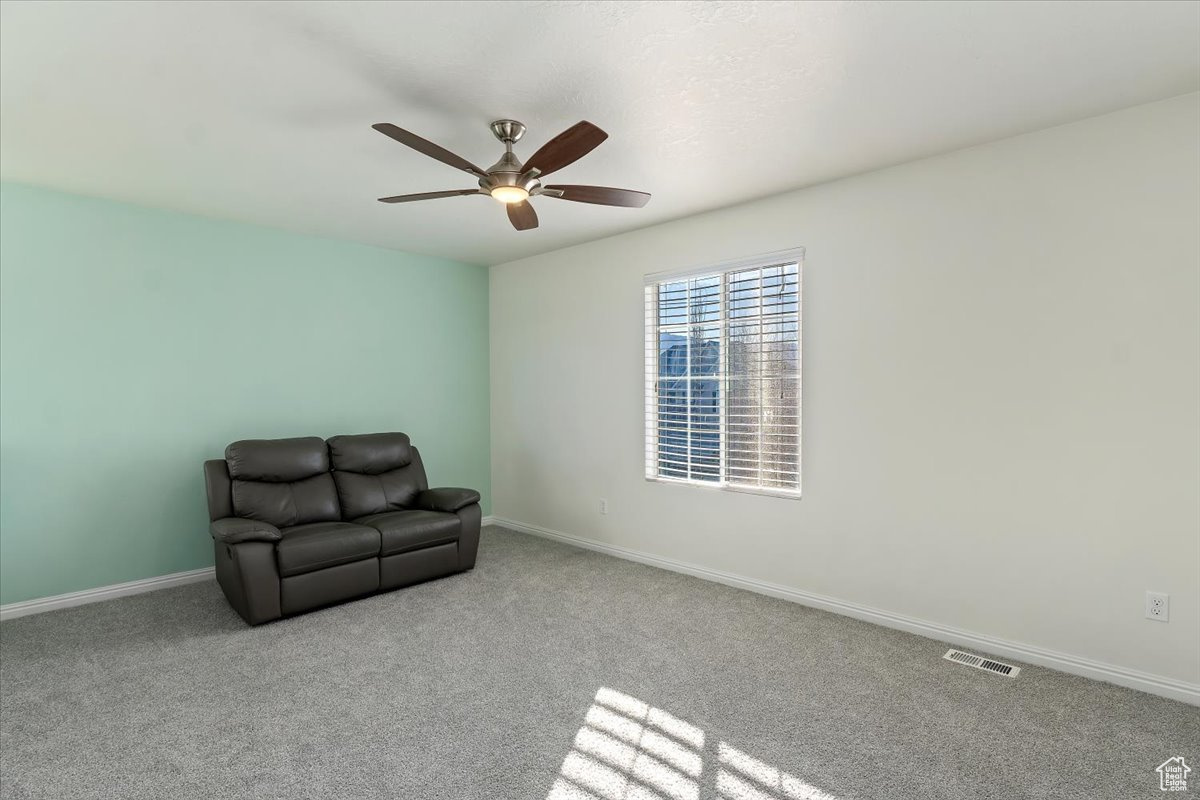 Unfurnished room with light colored carpet and ceiling fan