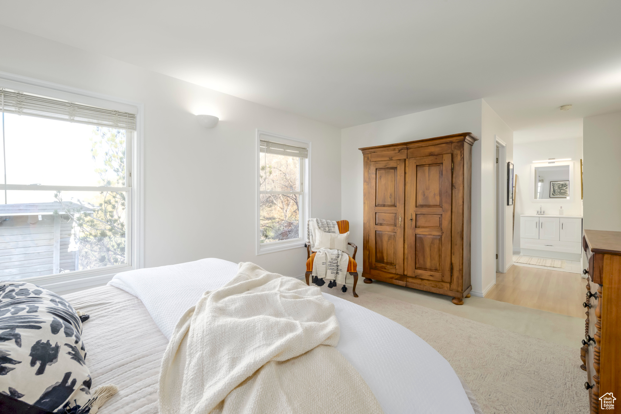 Bedroom featuring light carpet and ensuite bath