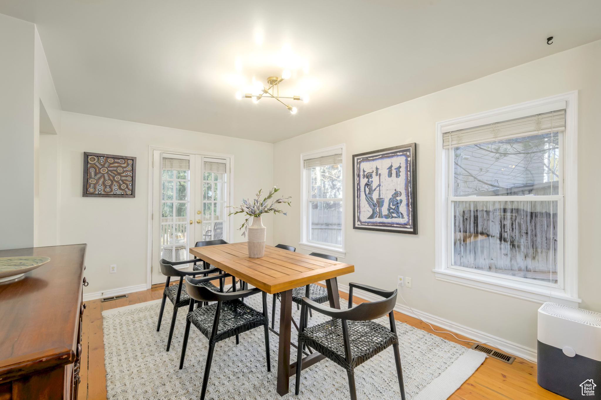 Dining area featuring french doors, light hardwood / wood-style floors, and a notable chandelier