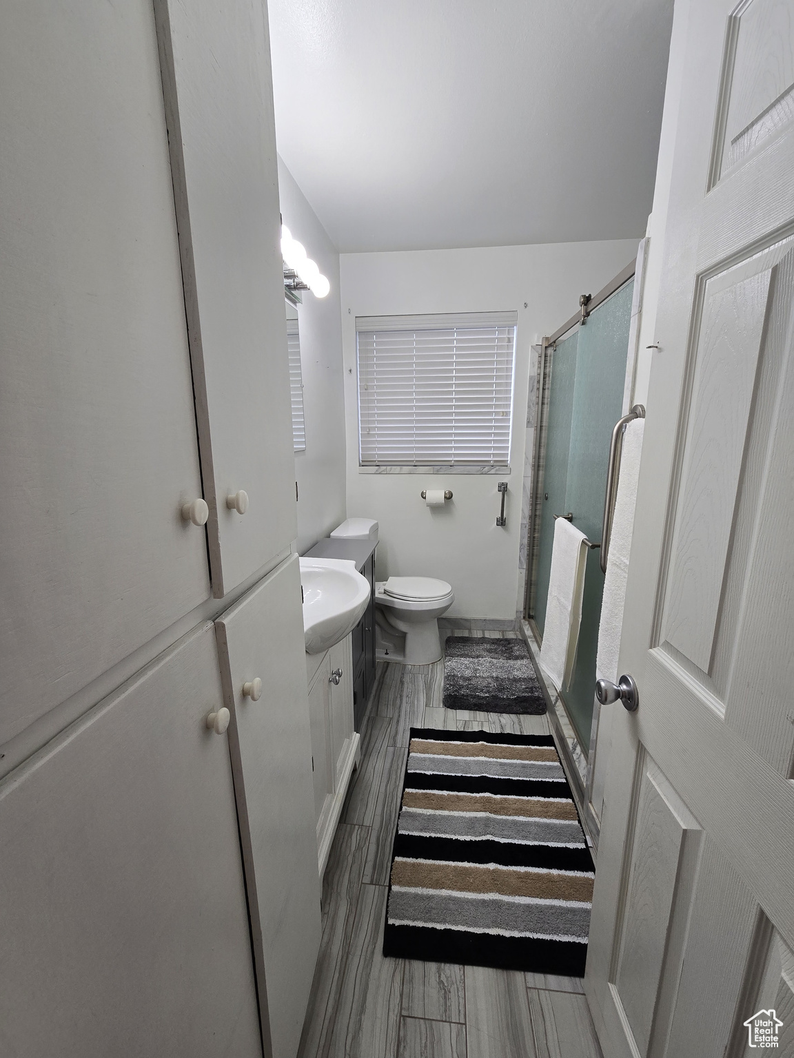 Bathroom with vanity, toilet, and an enclosed shower